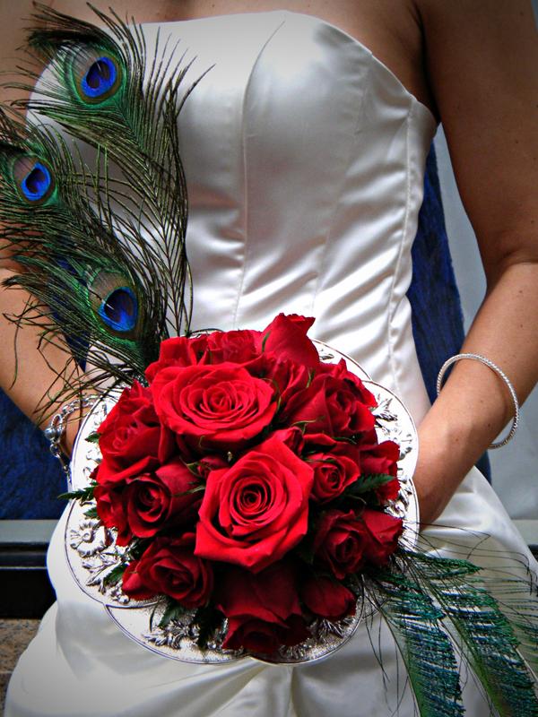 Bouquet holder showing an arrangement of striking roses with peacock 